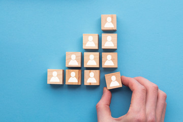 Hand adding a new team member to a group. Business management concept