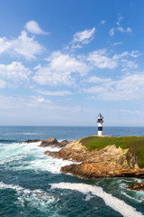 Fototapeta na wymiar Lonely lighthouse on the coast of Galicia, Spain. Island of Pancha near Ribadeo