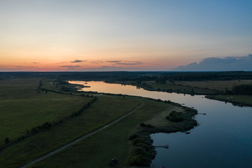 flight over the lake and forest at sunset in summer (photo from drone )