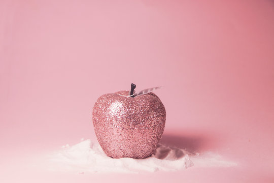 Pink glittering apple in snow. Concept for Rosh hashanah, New Year holidays