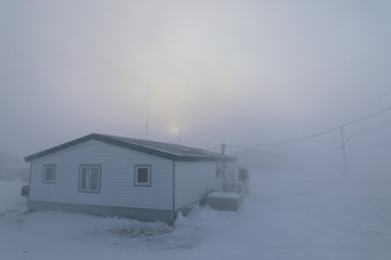 Blizzard conditions in Arviat, Nunavut Canada during December month.  House almost completely gone under winter conditions in the Canadian Arctic