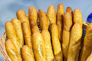 Baguettes in early morning sunlight by a windowsill in a bakery with other breads