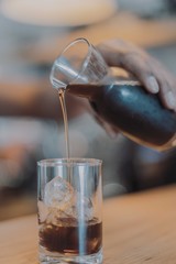 Cold brewed coffee being poured into a chilled shot glass 