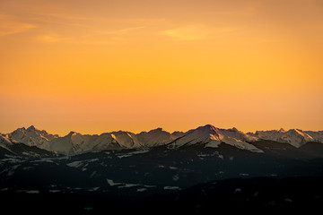 Obraz premium Snowy rocky mountain with a beautiful pink sunset, space fort text