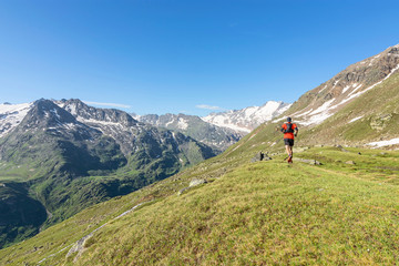 Fototapeta na wymiar Mountain runner in the Oetztal Alps at a beautiful day in summer. Alpine landscape with rocky mountains, glaciers and green pastures under blue sky. Tirol, Austria.