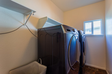 Large laundry room with built-in shelves but electric outlet in the wrong place