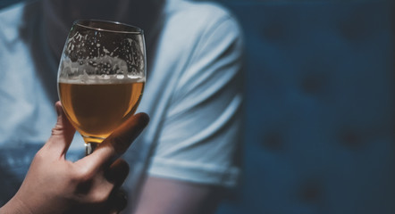 man holds a glass of beer in his hand at the bar or pub