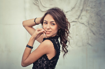 Portrait of a beautiful sexy woman with fashion makeup on face and long black hair. Glamour girl poses over relief creative background