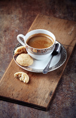 Cup of coffee with amaretti (Italian biscuit) on rustic background. 