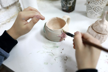 Fototapeta na wymiar Person painting clay mug