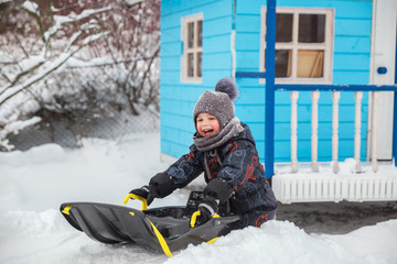 Fototapeta na wymiar Little boy sledding in winter