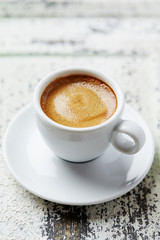 Cup of coffee on white wooden background. Close up. 