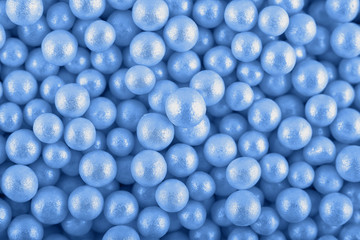 Candy sugar pearls, cake decoration, copy space. Small silver sparkle balls texture. Classic blue background. Color of the year 2020. Top view, flat lay