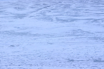 Blurry human's silhouettes on frozen lake. Cropped shot of frozen lake. Abstract winter background. Winter landscape.