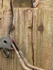 Detail of an old clothes hanger on a wooden board.