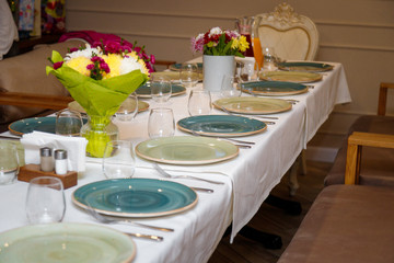 table set for festive dinner with flowers, plates and glasses