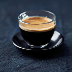 Coffee in glass cup on dark background. Close up. 