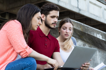 Group of  University students studying together outdoors