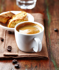 Cup of coffee with cantuccini  (Italian cookies) on rustic wooden background. 