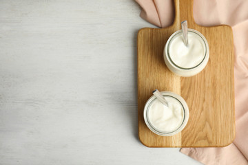 Tasty organic yogurt on white wooden table, flat lay. Space for text