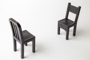 Black retro chairs against white background minimal creative concept.