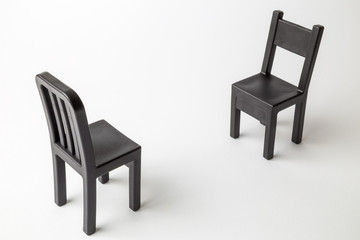 Fototapeta premium Black retro chairs against white background minimal creative concept.