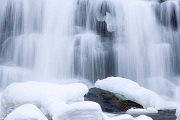 Winter, Bond Falls cascade captured with motion blur and framed by ice and snow, Michigan's Upper Peninsula, USA 