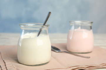 Tasty organic yogurt on fabric against light blue background. Space for text