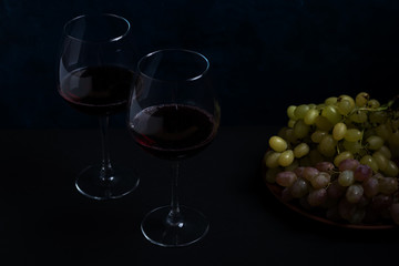 red wine and grapes on a dark background