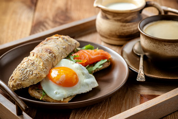  Arugula, salmon and runny egg sandwich, homemade breakfast. 