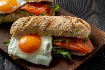  Arugula, salmon and runny egg sandwich, homemade breakfast. 
