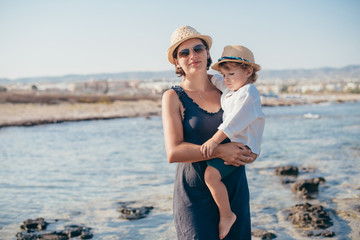 Mom with a little son on a trip near the sea.