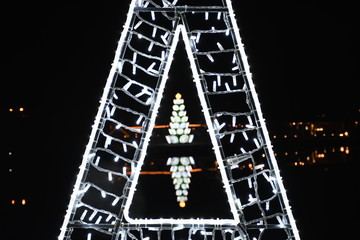 Christmas tree in a triangle of lights at night