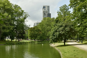 Le parc Léopold avec son étang et la tour d'appartement de haut standing émergeant de la nature luxuriante ,au Quartier Européen de Bruxelles