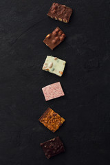 Сhocolate plates flat lay view on dark background, top of view