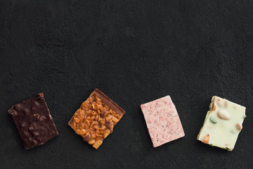 Сhocolate plates flat lay view on dark background, top of view