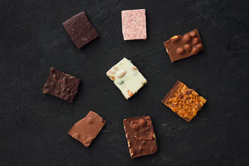 Сhocolate plates flat lay view on dark background, top of view
