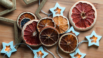 Christmas still life of citrus on a tree background, with garlands and a Christmas star.