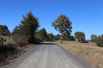 Perspective view down a lonely country road under a brilliant blue sky