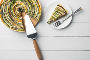 traditional french ratatouille vegetable pie on a white wooden background with cut out slice
