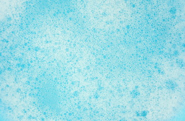 Fototapeta na wymiar Foam bubble from soap or shampoo washing on blue background, top view. Foam background. White foam.