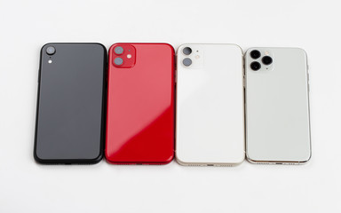 Four smartphones of different colors close-up on a white background.