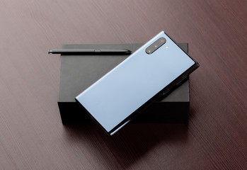 A smartphone with three cameras on a box close-up.
