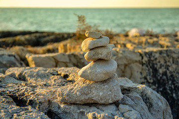Fototapeta na wymiar Torre di pietre sugli scogli di fronte al mare