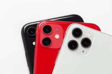 Three smartphones close-up on a white background. - obrazy, fototapety, plakaty