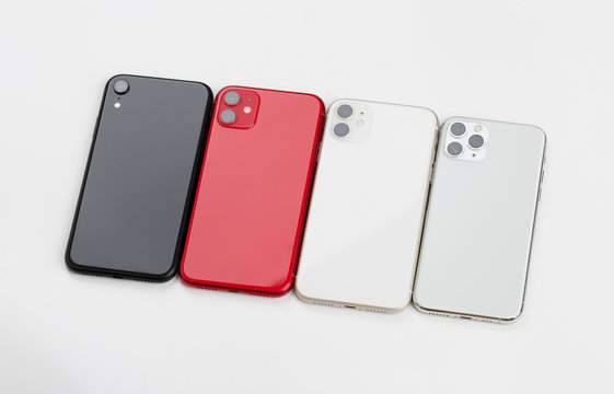 Four smartphones of different colors close-up on a white background.