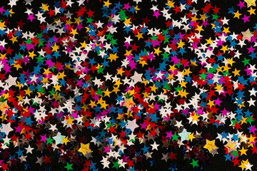 Black abstract background with multicolored particles like snow stars for use on Christmas or New year banners flyers greeting cards. Vector image
