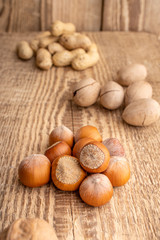 Inshell hazelnuts. Nuts mix on the old rustic wooden background. Food for man's and women health. Raw foods for vegetarians and vegans.
