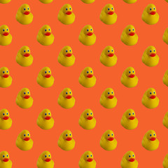 Digital seamless pattern of yellow rubber duck on orange background