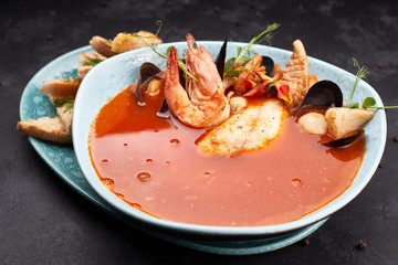 Seafood Tomato Soup, on a dark background, Bouillabaisse